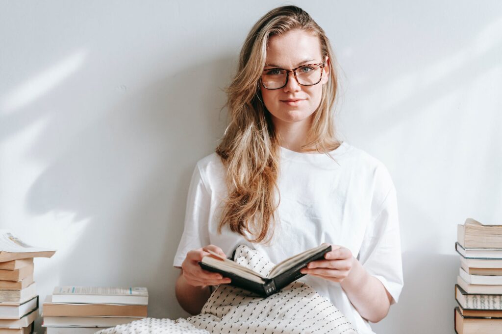 smiling student with agenda between books in house