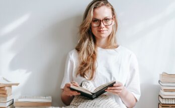 smiling student with agenda between books in house