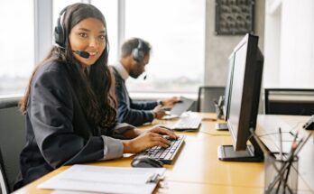 a smiling woman working in a call center while looking at camera