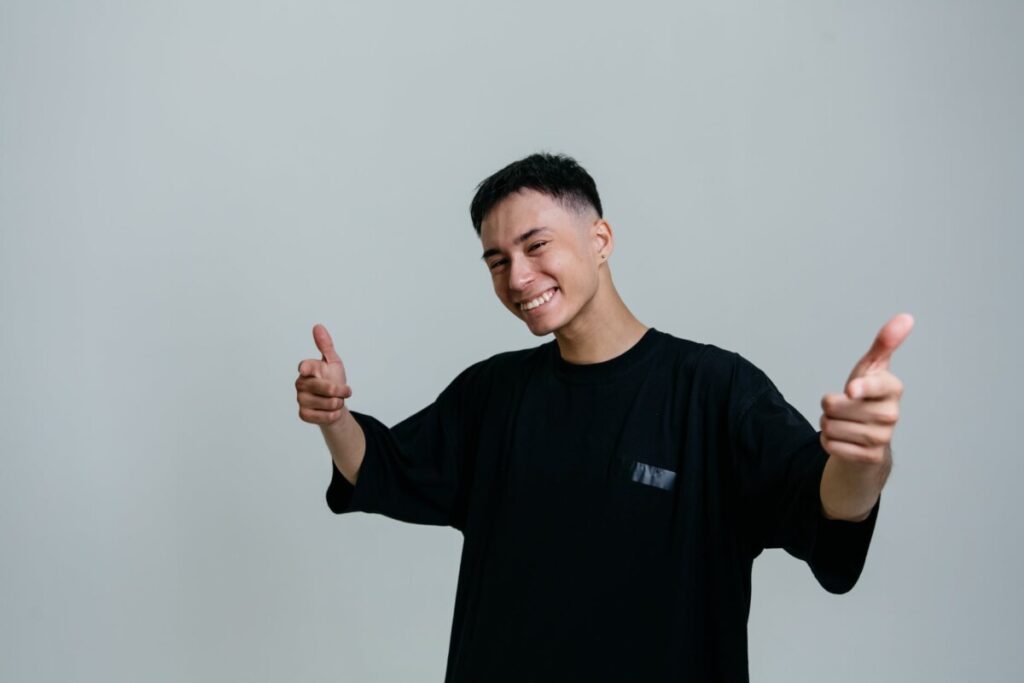 man in a black crew neck shirt pointing his fingers at the camera