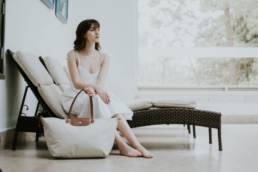 portrait of woman in white dress sitting on deckchair