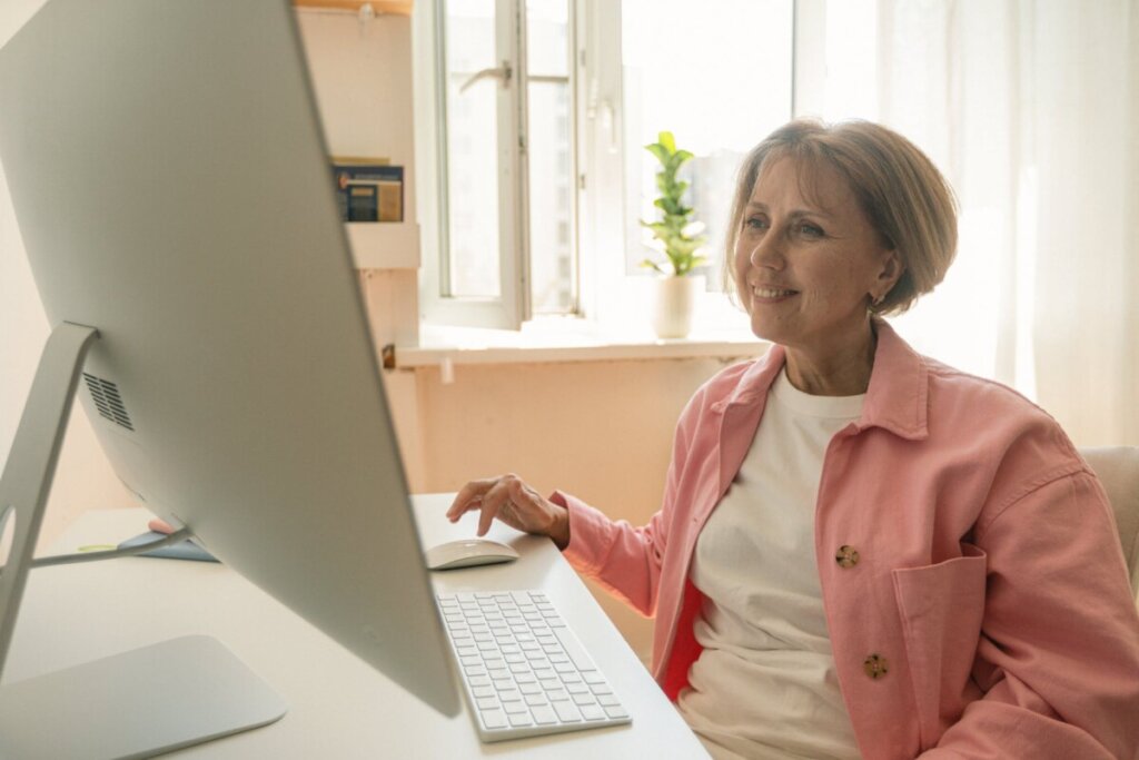 an elderly woman using a desktop computer